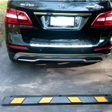 Black Mercedes-Benz car parked next to a speed bump on a concrete surface.