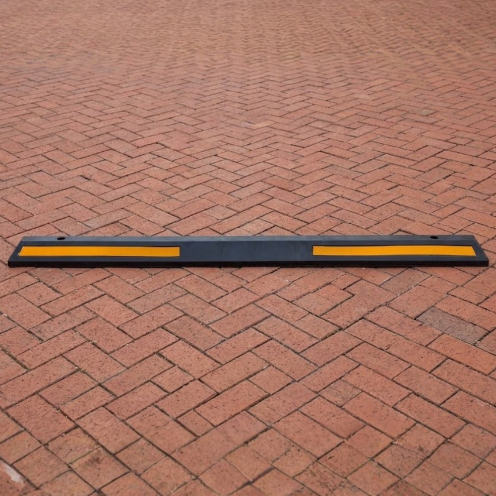 Base Guard® 2000mm Rubber Wheel Stop on a brick pavement