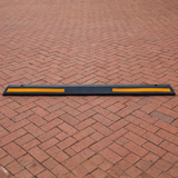 Base Guard® 2000mm Rubber Wheel Stop on a brick pavement