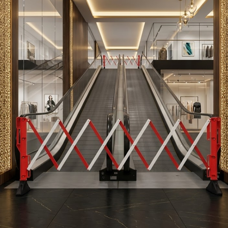 Escalator in a modern building with red and white barriers