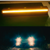 Reflective strip glowing yellow on a dark background with headlights shining brightly below.