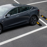 Gray car approaching a speed bump on a road