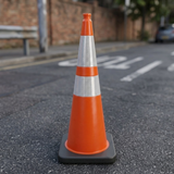 Orange traffic cone on a road with a blurred background