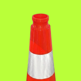 Red and silver traffic cone on a green background