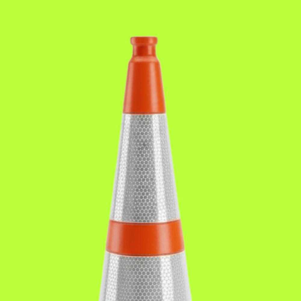 Traffic cone with orange top and reflective silver body on a green background