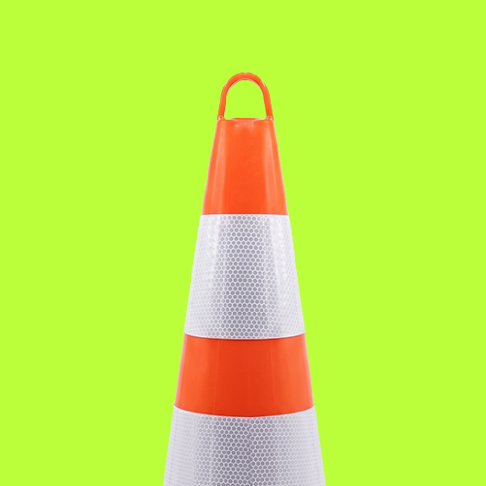 Traffic cone with red top and base on a green background