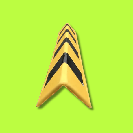 A yellow V-shaped traffic safety barrier with bold black chevron stripes, shown on a solid lime green background.