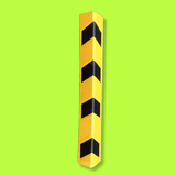 A yellow corner guard with four black chevron stripes, shown vertically on a solid lime green background.