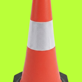 Red traffic cone with a white stripe on a green background