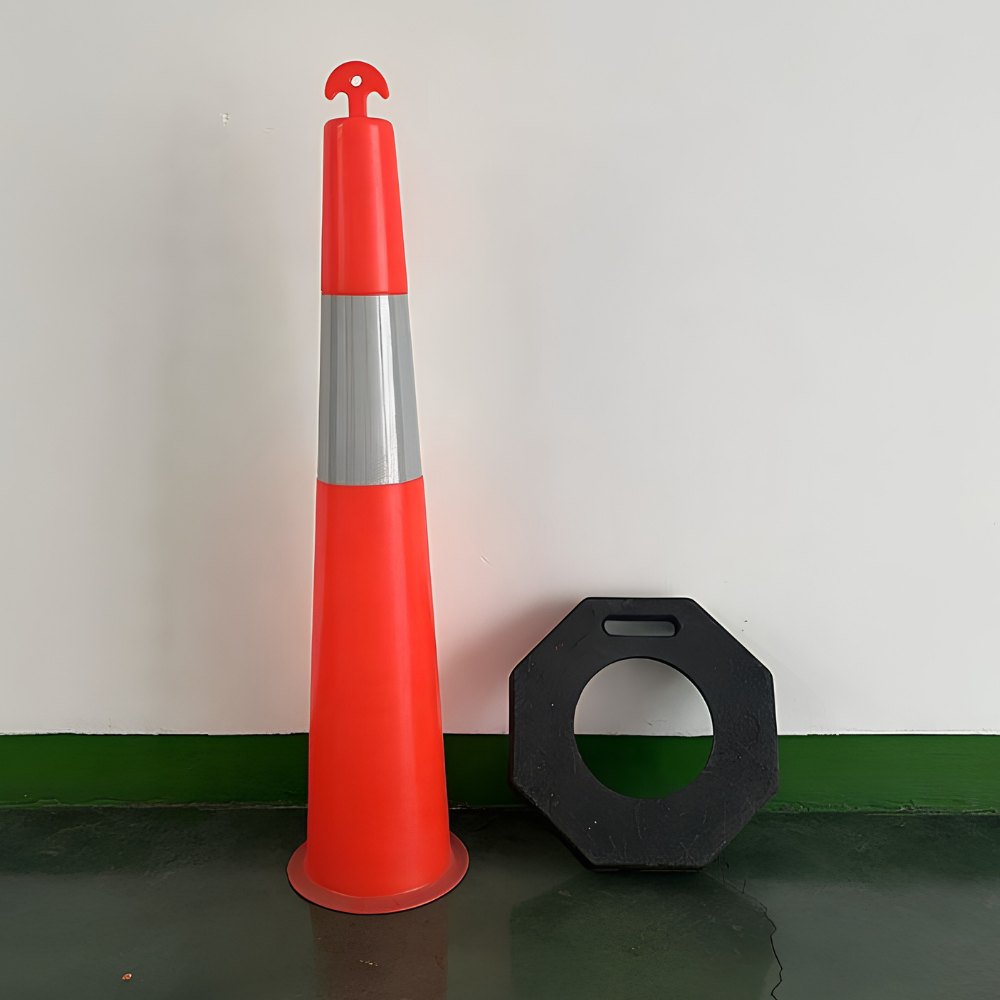 Orange traffic cone with reflective silver band and black octagonal sign on a green and white floor.