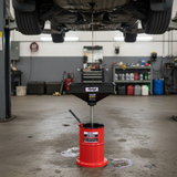 Car being serviced with an oil drain pan and funnel in a garage setting