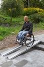 FEAL telescopic portable ramps in use, wheelchair coming down a step