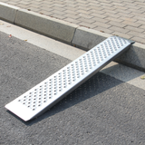 Metal ramp on a paved road next to a curb