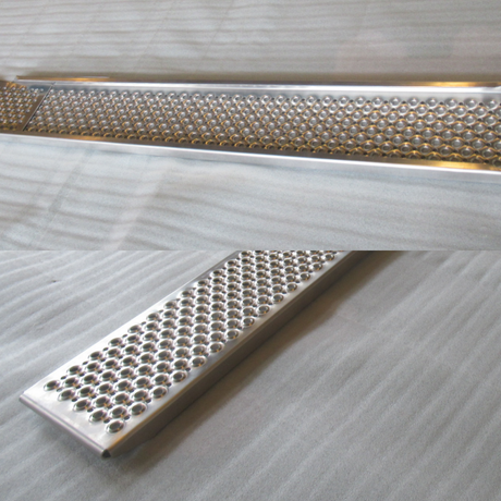 A two-panel, close-up view of an aluminum ramp section featuring a highly textured, non-slip punched mesh surface.