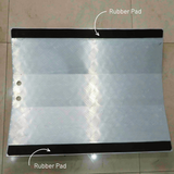 Metallic sheet with rubber pads labeled on a tiled floor background