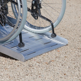 Heeve® Aluminium Non-Folding Wheelchair Ramp with Open Grid Deck on a gravel surface
