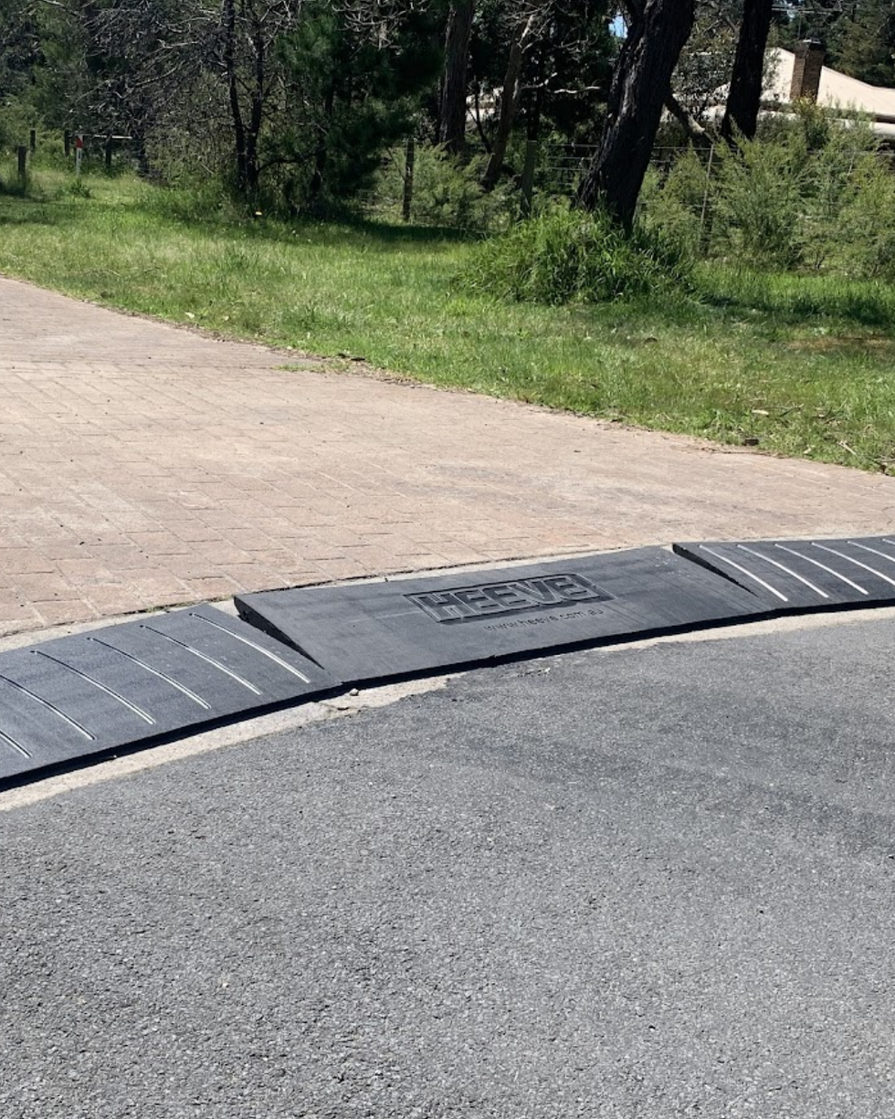 Heave brand name on a set of rubber ramp leading to a driveway.