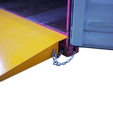 Side view of a yellow Heeve self-supporting forklift container ramp, showing the forklift tyne slots and the anti-skid surface.