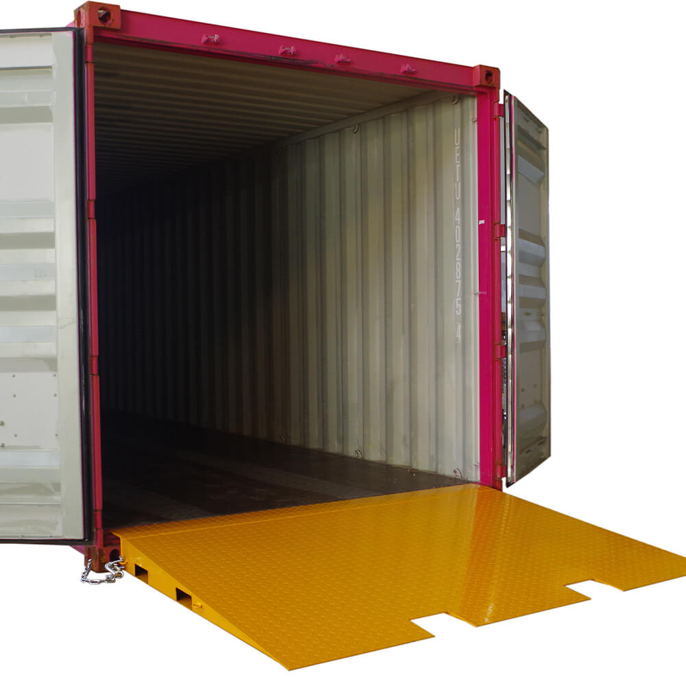 A yellow Heeve self-supporting forklift container ramp placed in front of an open shipping container, showing the forklift tyne slots and the anti-skid surface.
