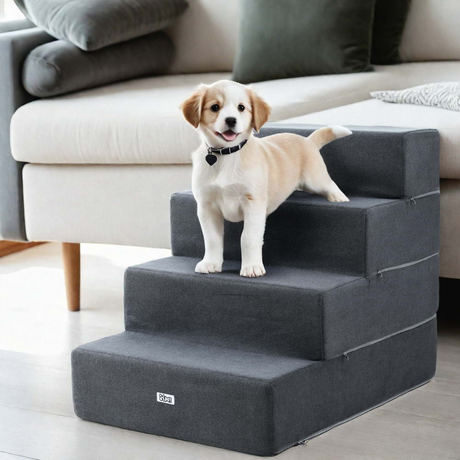 Dog standing on a set of gray pet stairs in a living room.
