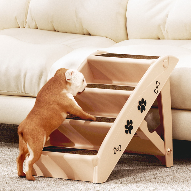 Dog using a set of beige pet stairs to climb onto a couch.