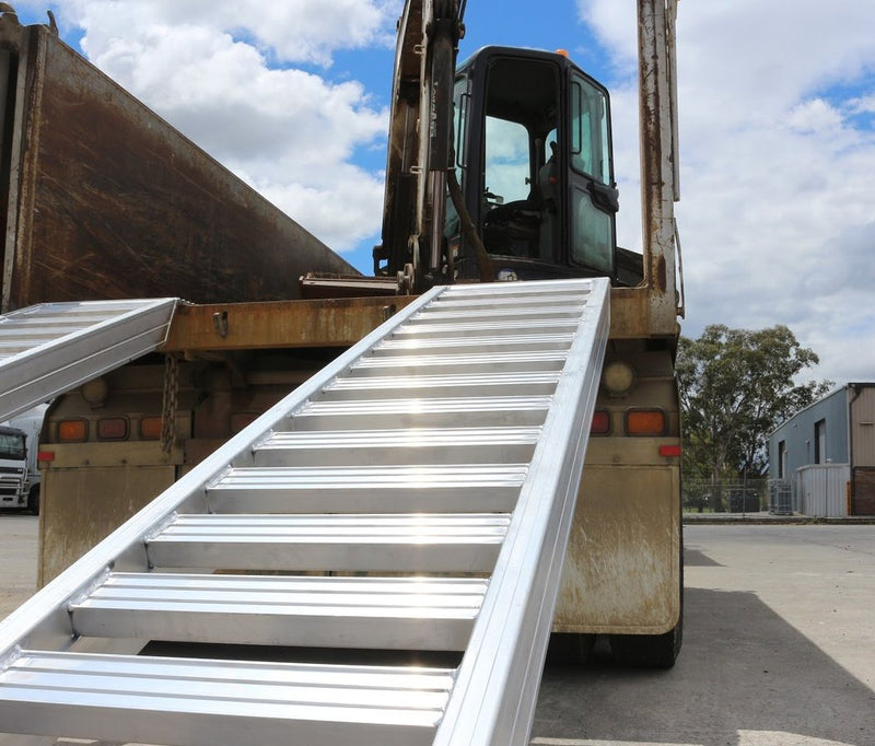 Heeve aluminium loading ramps on a truck with an excavator