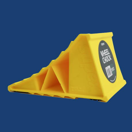 Yellow wheel chock with a label on a blue background
