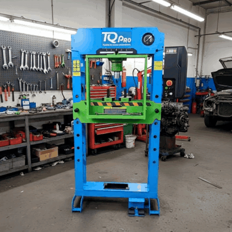 Blue and green hydraulic press with 'TQ Pro' branding in a workshop setting.
