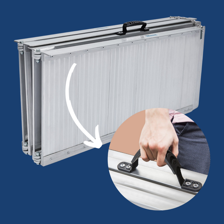 Ramp being folded by hand, showing lightweight design and carry handle.