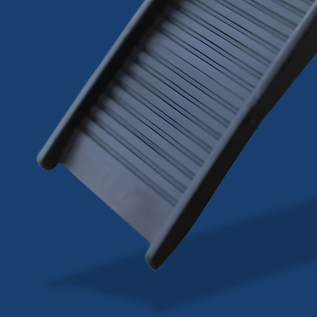 Gray rectangular object with textured surface on a blue background