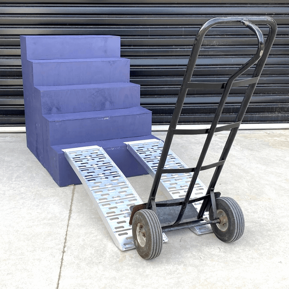 Hand trolley on blue steps using a pair of aluminium curved ramps.